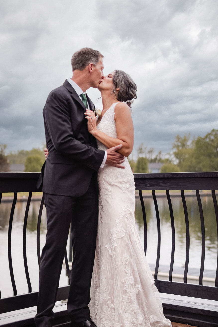 dreary wedding day bride and groom kissing on the water. The Pier Central Square, NY 
Copyright 2023 LT² Photography