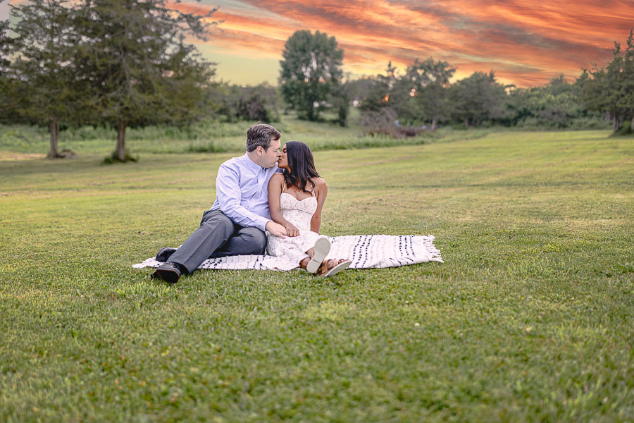 Engagement session. Couple kissing on a picnic blanket. Three Mile Bay, NY. Northern New York Wedding Photographer. Long Island Weddings. Fairytale wedding photography.