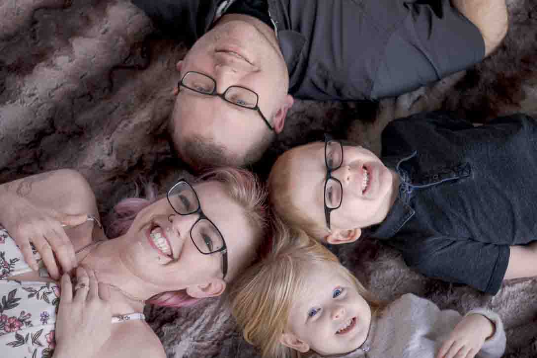 Family portrait - mom, dad, brother & sister lying head to head smiling faces 
Indoor studio sponsored by Comfort Inn & Suites Watertown, NY
