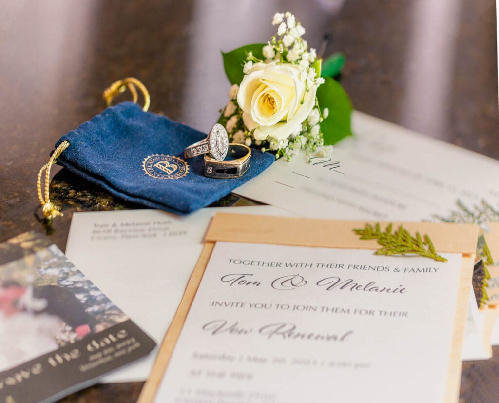 Vow renewal invitation suite with wedding bands and elegant floral accents.