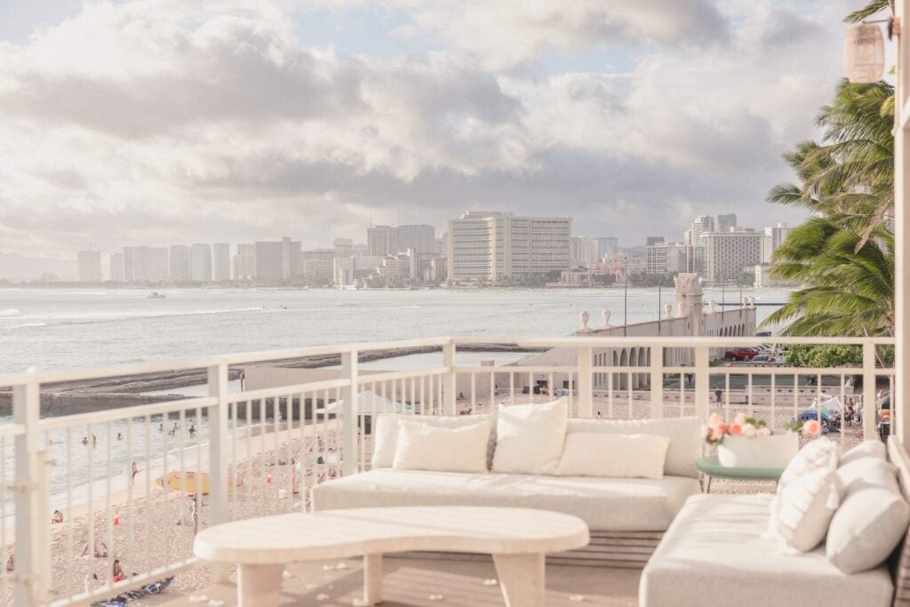Oceanfront lanai lounge at Kaimana Beach Hotel with views of Waikiki Beach and the Honolulu skyline