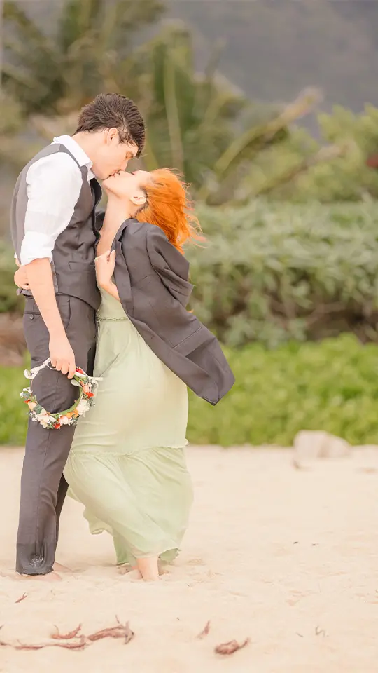 Hawaii Engagement Photographer. Couple shares a kiss on Waimanalo Beach at sunset