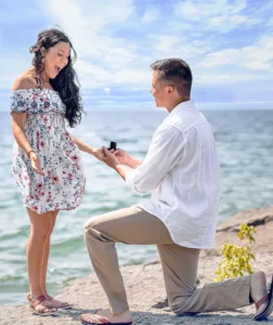 Man proposing to surprised woman during a lakeside summer engagement, captured by oahu proposal photographer, LT² Photography