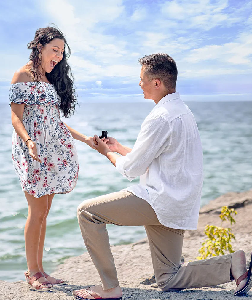 Man proposing to surprised woman during a lakeside summer engagement, captured by oahu proposal photographer, LT² Photography