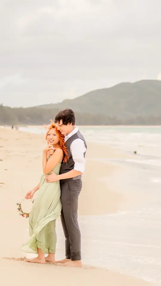 Couple embracing on Waimanalo Beach at golden hour