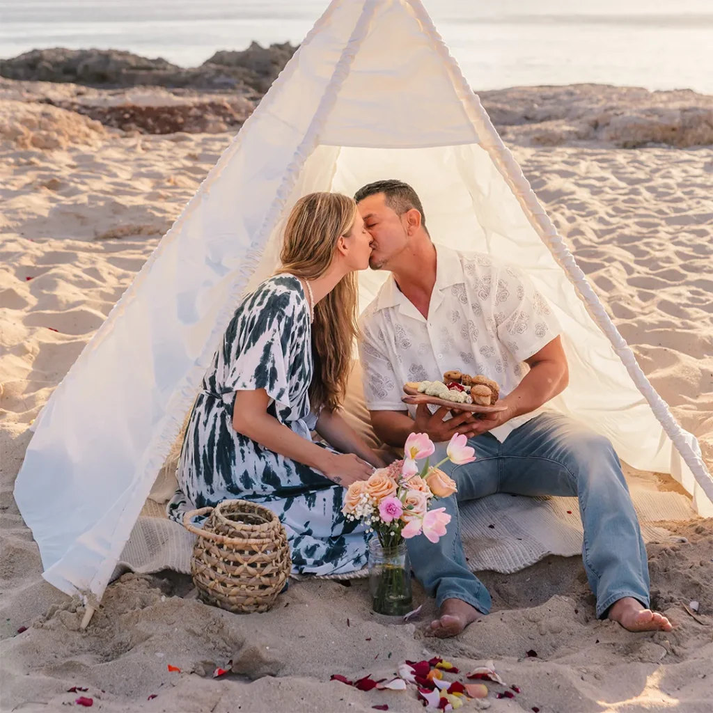 hawaii beach proposal. Cheyenne and Loraine share a kiss inside their teepee during a picnic on the beach after their Hawaii proposal.