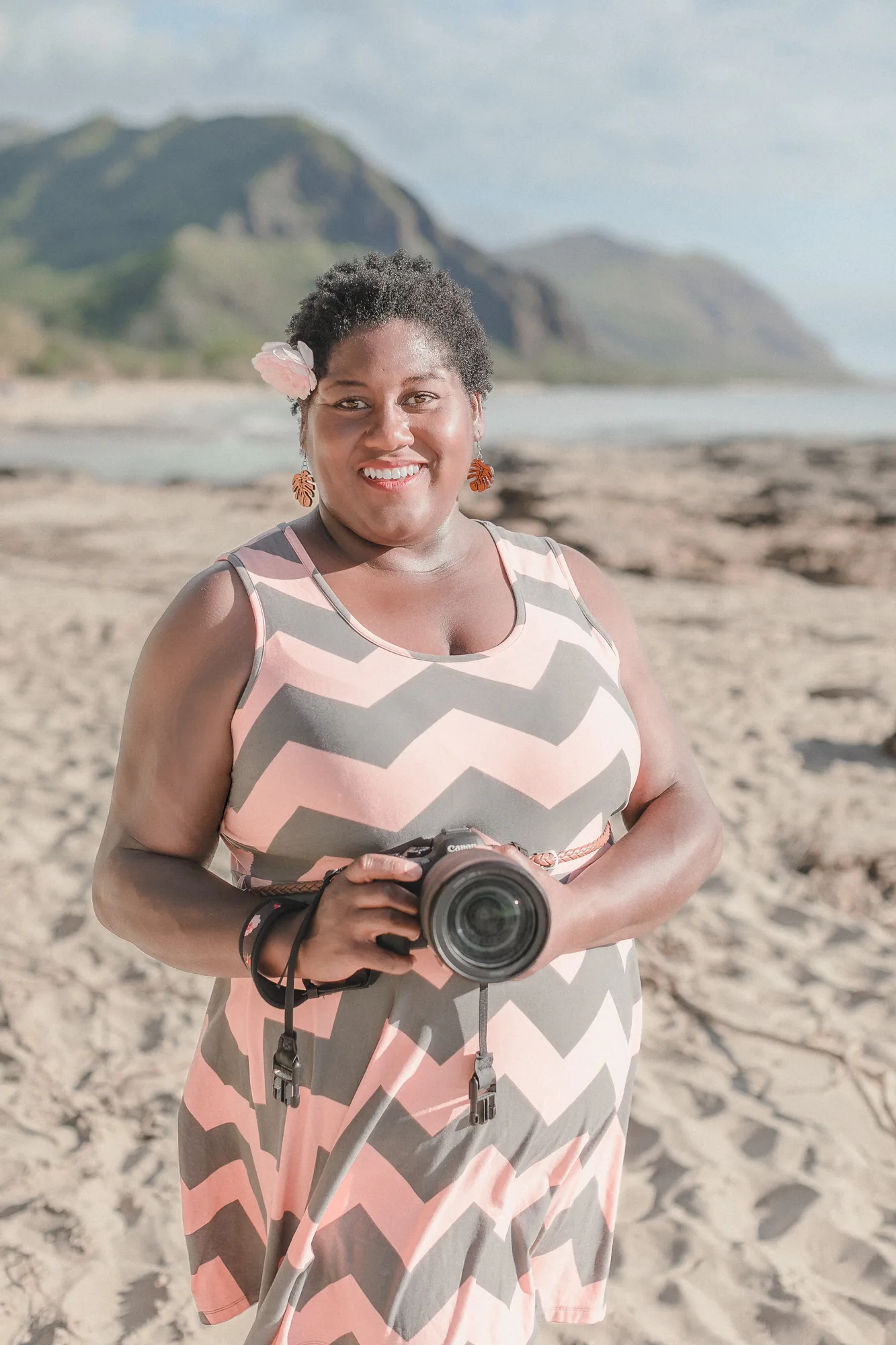 LaDonna Takyi Taylor, Hawaii wedding photographer, smiling on an Oahu beach holding her camera